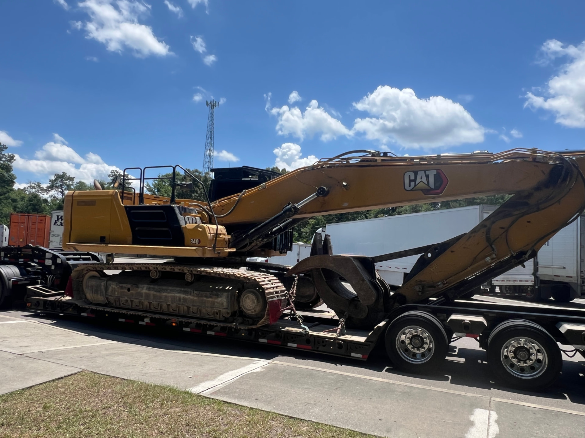 CAT 340 excavator chained to a flatbed trailer ready for transport to a Central Florida land clearing job site