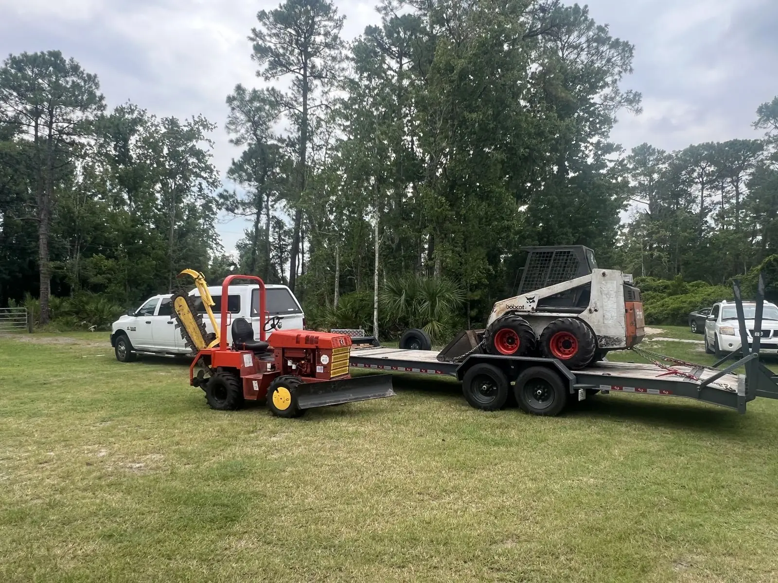 Trencher and loaded equipment trailer ready for underground utility work near Oviedo